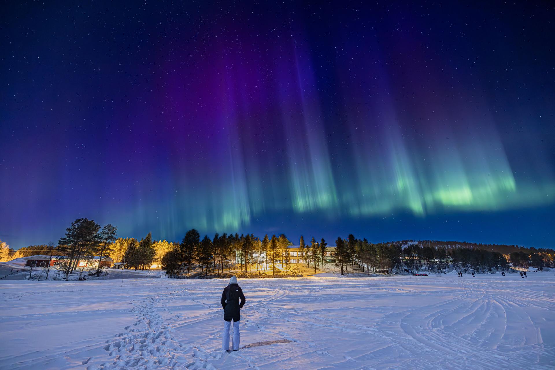 Young girl watching purple, blue and green Northern lights (aurora borealis)
