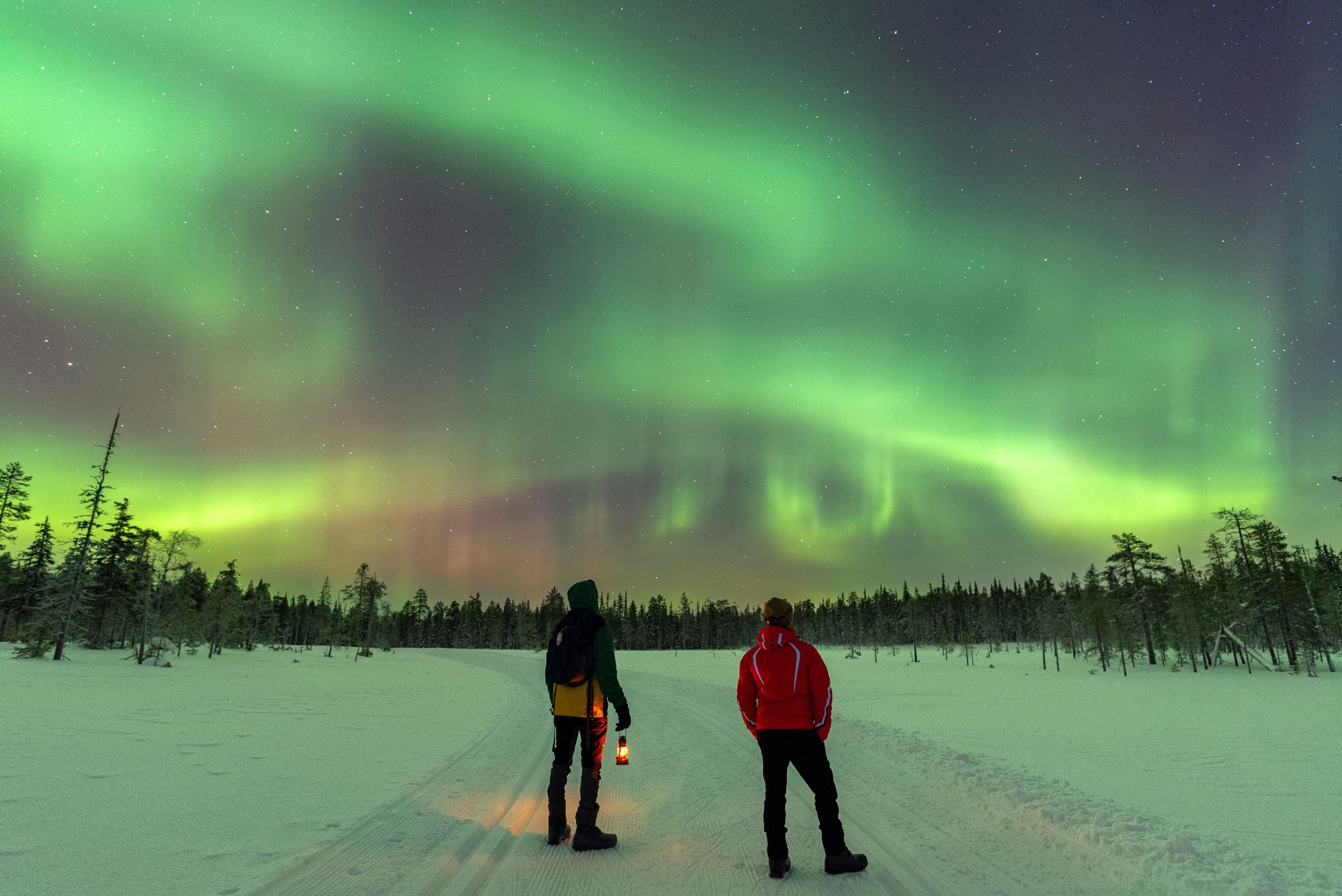 Two people enjoying the view of the northern lights, Lapland, Finland, Scandinavia
